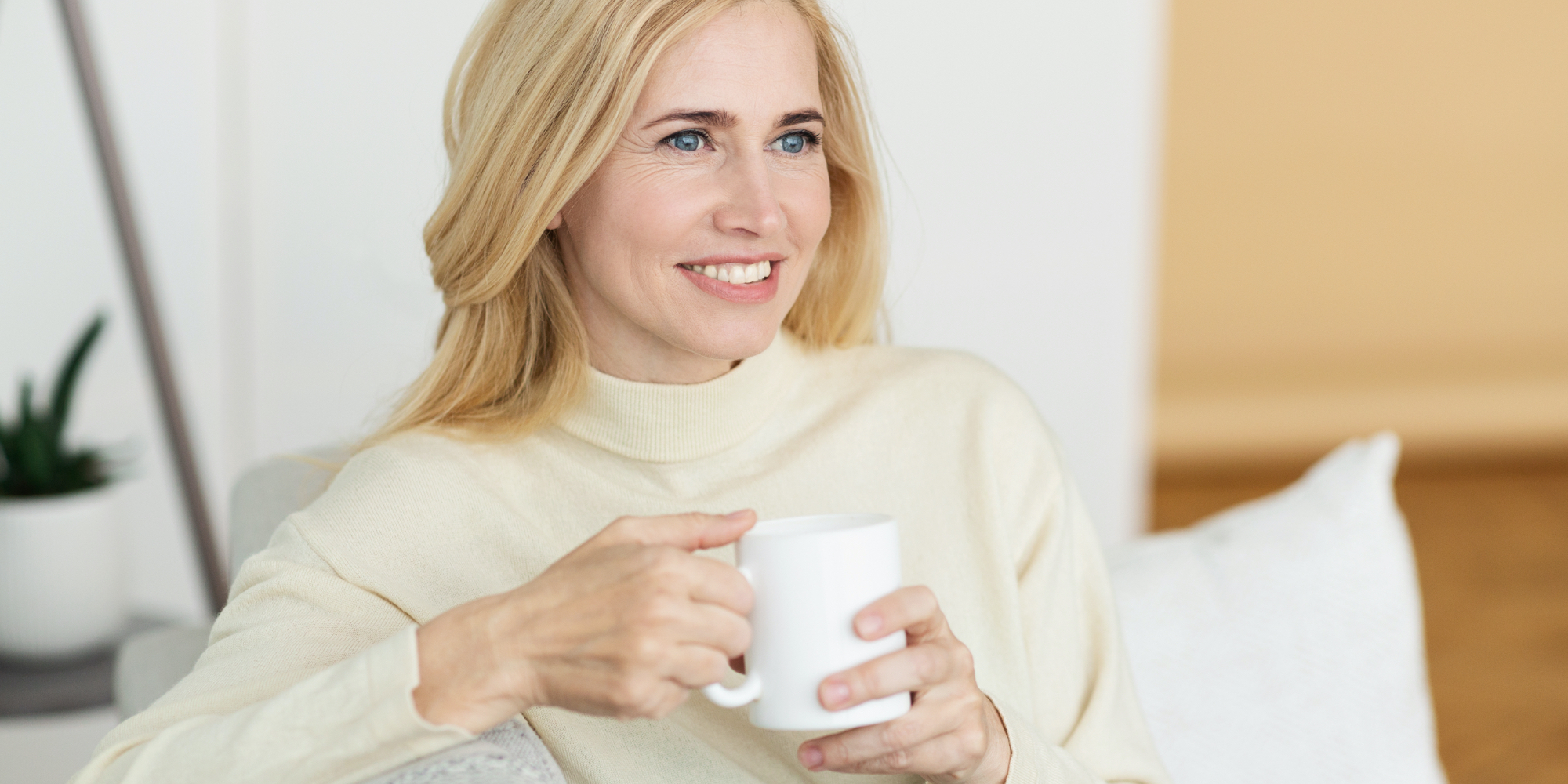 MIddle age woman holding a cup of coffee in her living room